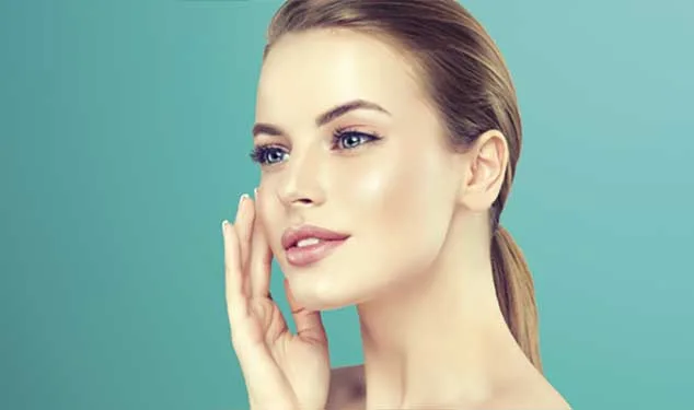Woman touching her face against a teal background for Morpheus8 skin remodelling in London